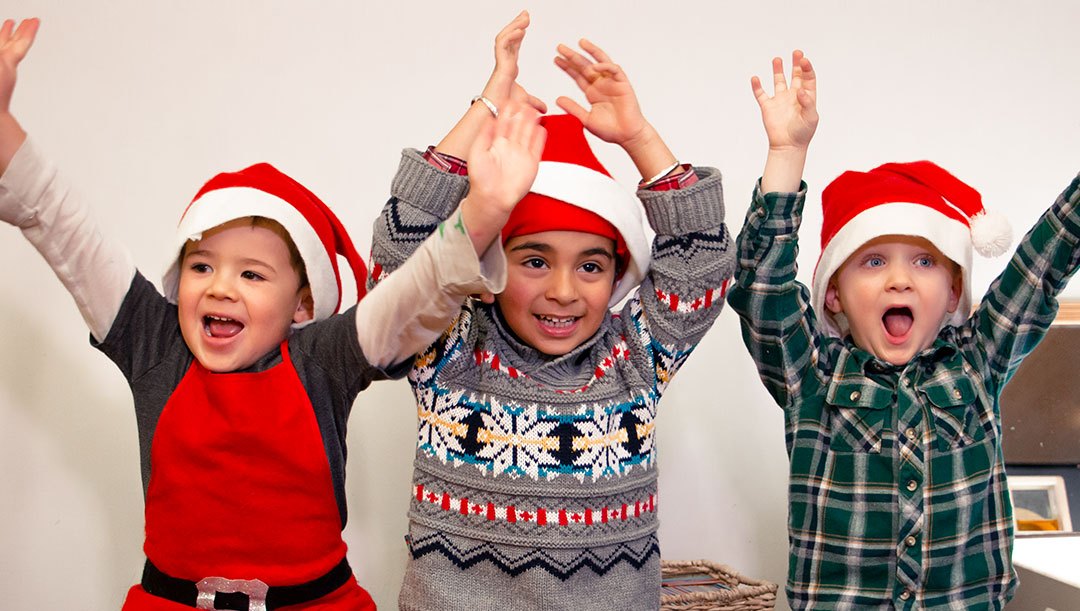 Winter Holiday Camps (grid content) Three children wearing Santa hats raise their arms happily