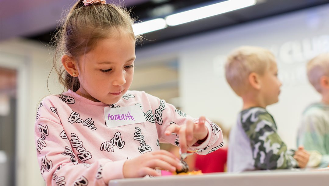 Pro D Day Camps (grid content) Girl enjoys making craft with careful focus