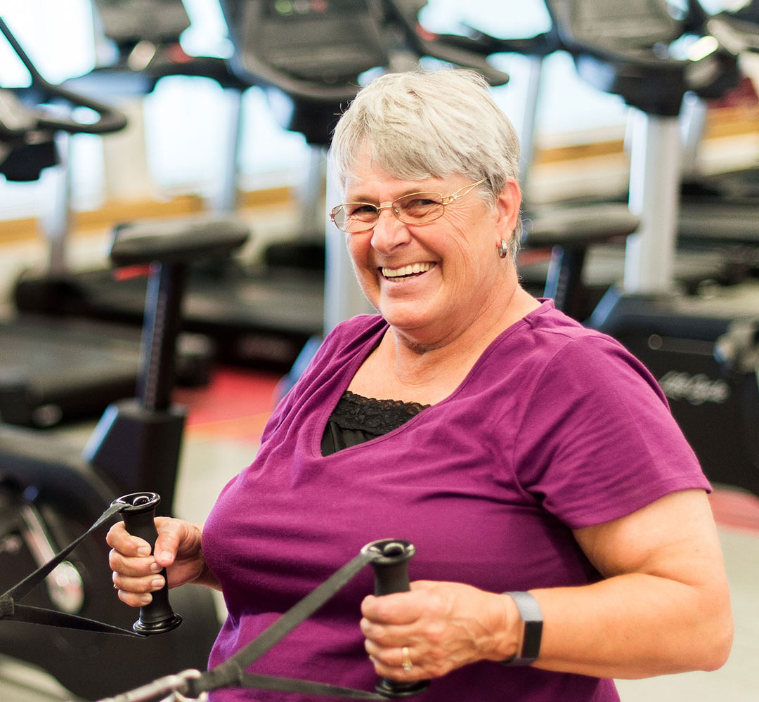 Individual Membership (teaser) senior woman using workout equipment