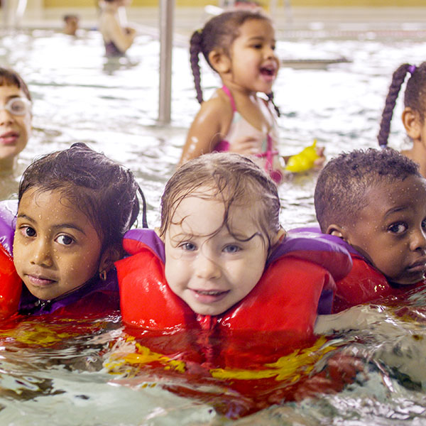 kids wearing lifejackets in pool