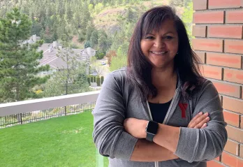 Maria smiling at her home