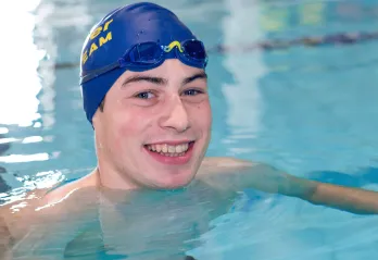 Zachary Bernier smiles up from Kelowna Family Y swimming lane
