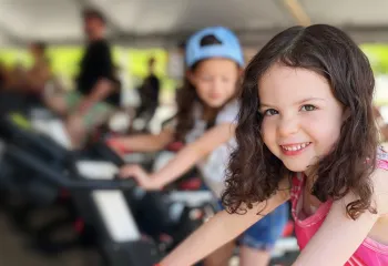 smiling girl riding stationary bike at the event