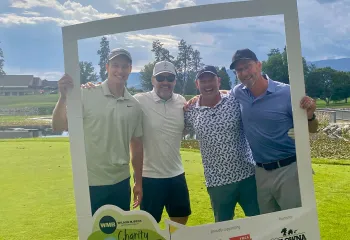 Wilson M Beck team standing behind giant photo frame on the golf course