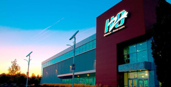 A large recreation building with a sun setting in the background. The sign reads 'H2O'. 