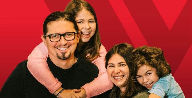 happy family in front of red backdrop