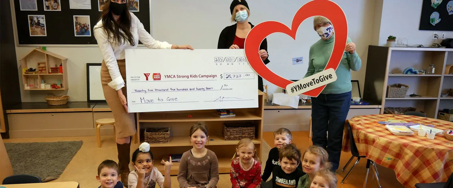 ladies holding cheque with kids in front