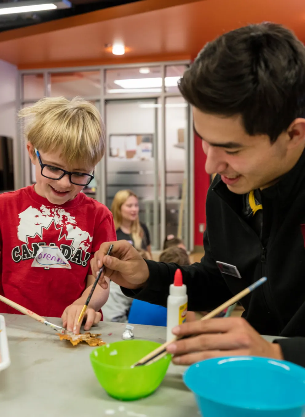 Staff member and child painting