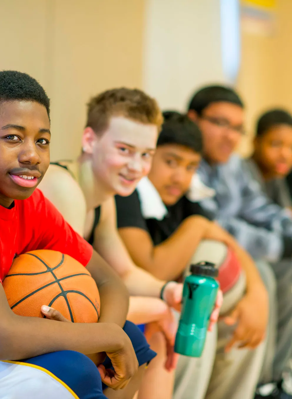Young guys sitting on the basketball bench