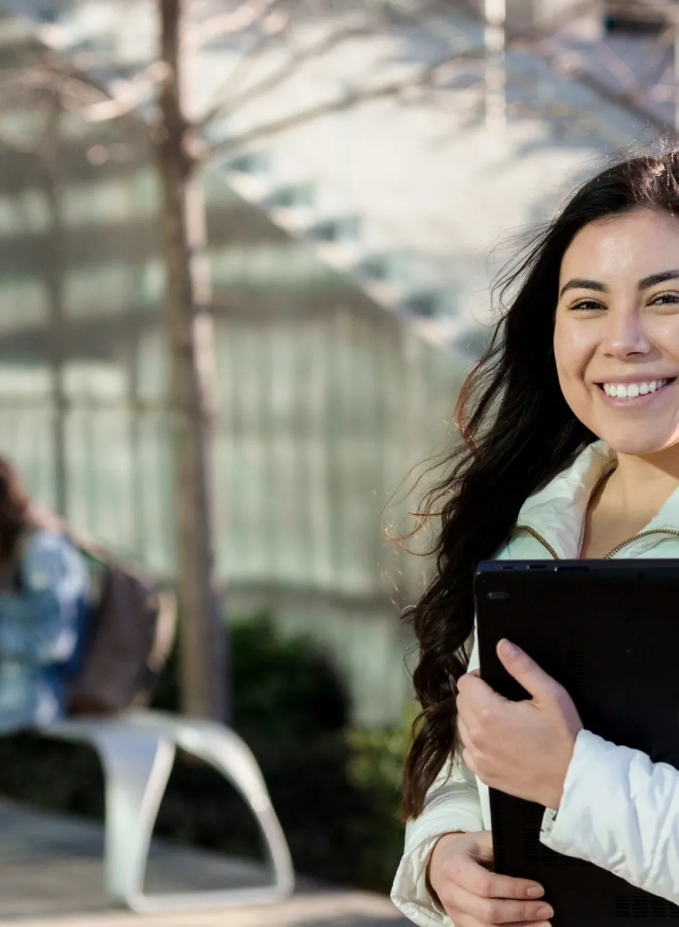 smiling young adult female student carries school supplies