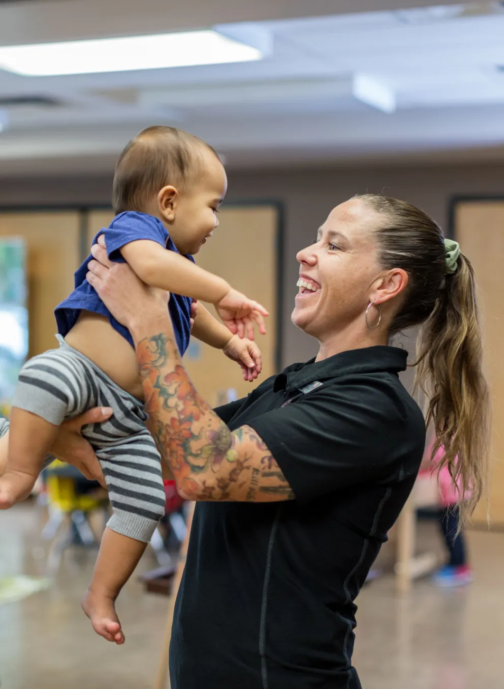 mom passes baby to YMCA child minding staff person