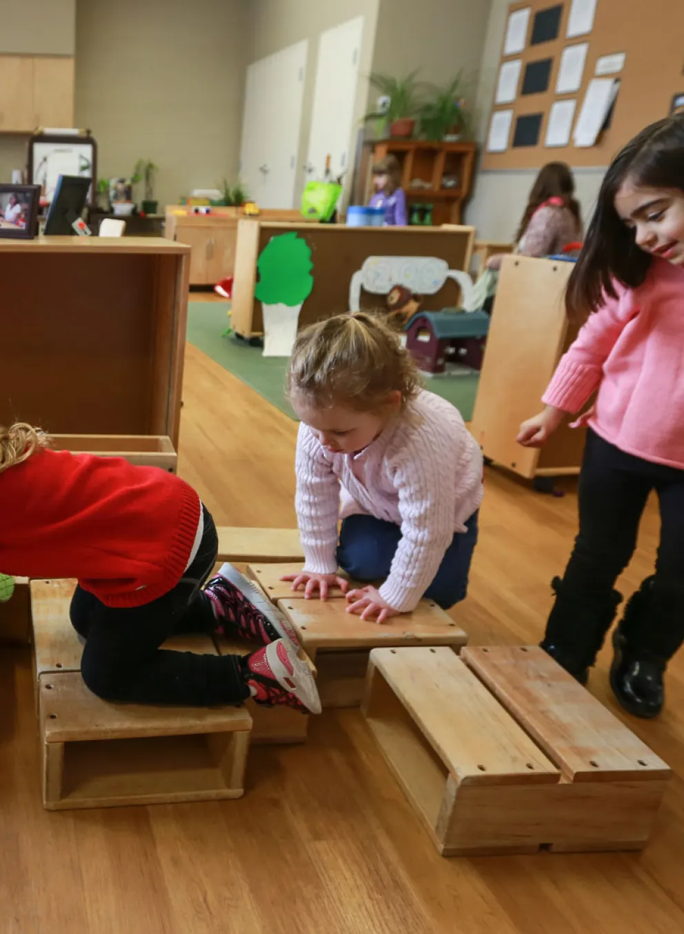 group of children playing on natural wooden blocks