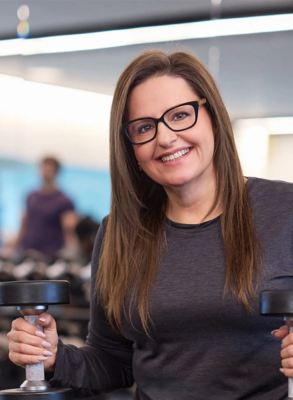 happy and confident woman holding weights