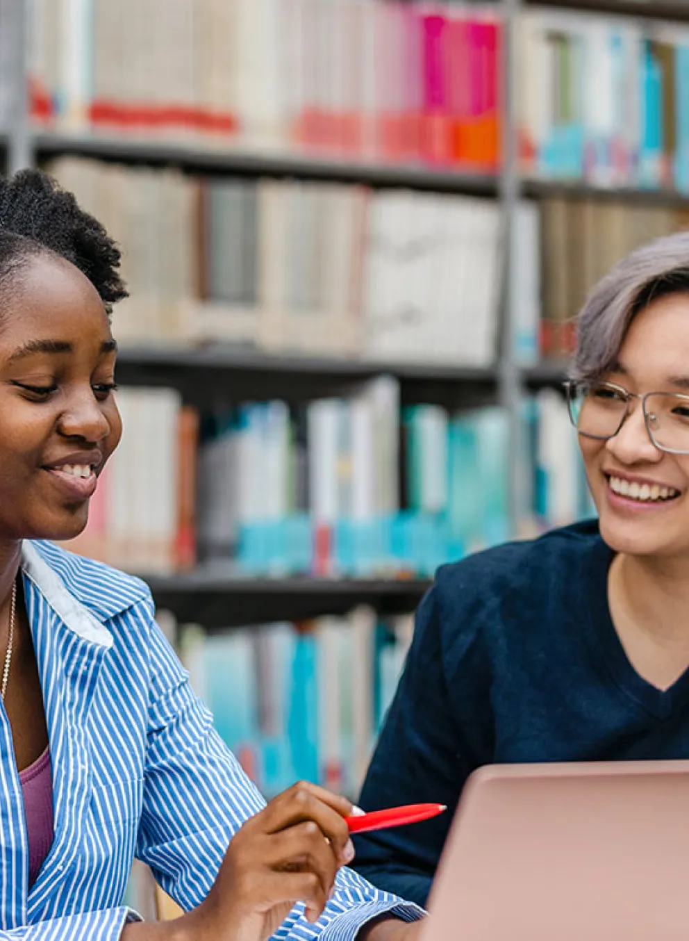three young people gather at a table with a laptop and notebooks