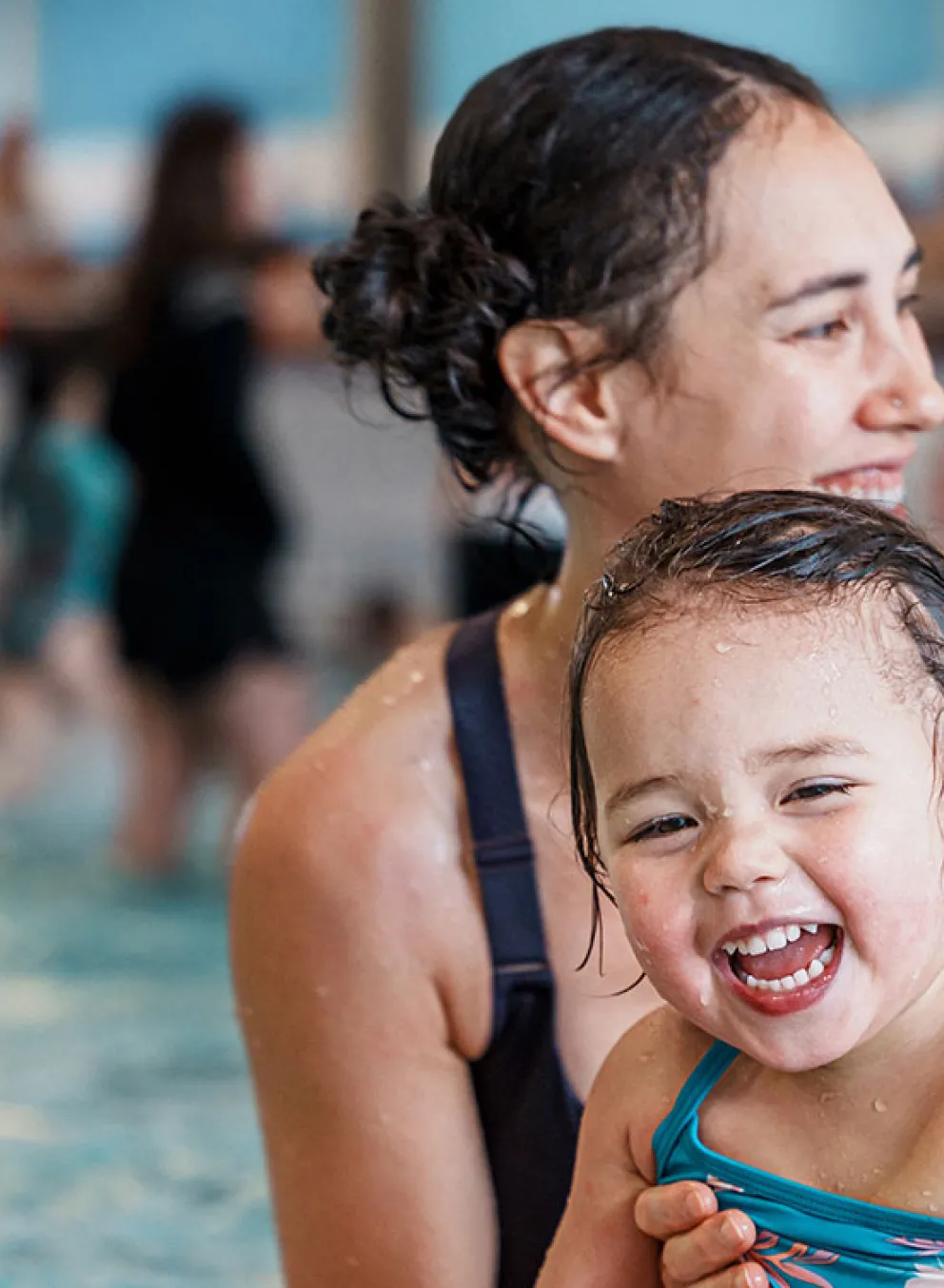 mother and young child having fun in a shallow pool area