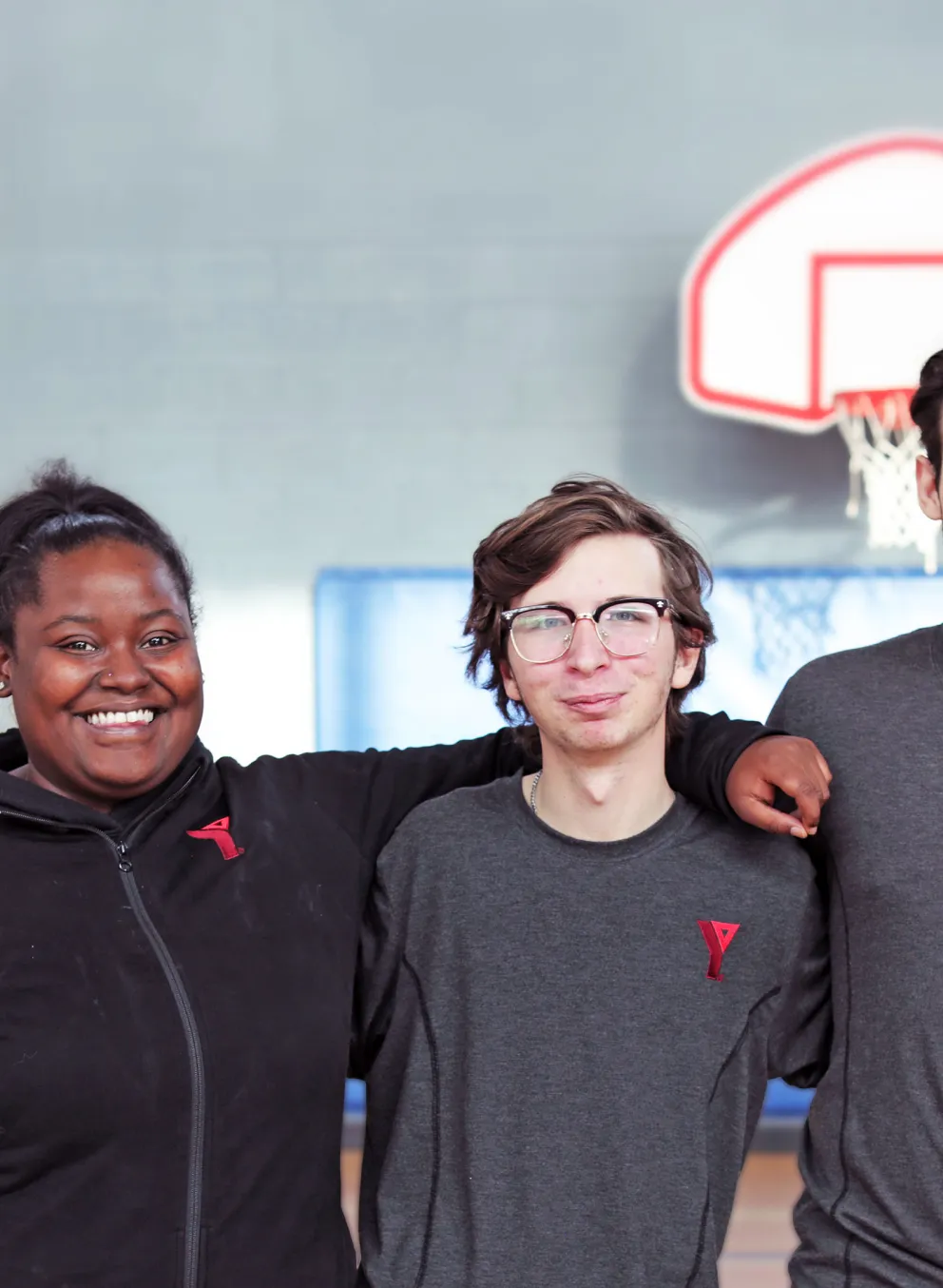 3 happy YMCA staff members in gymnasium