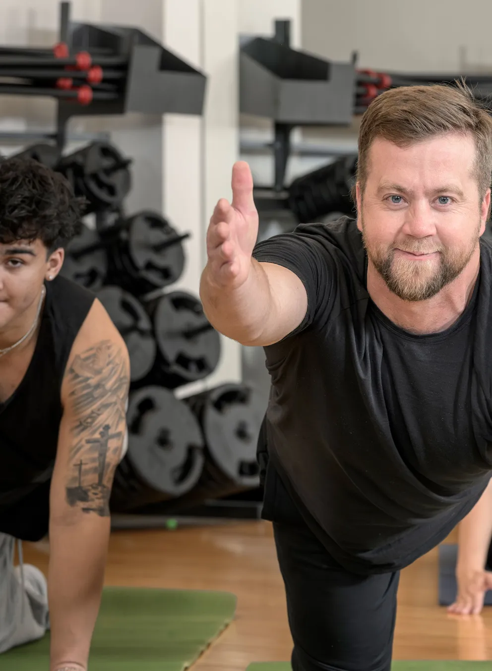 middle aged man participating in yoga class doing balancing table posemiddle aged man participating in yoga class doing balancing table pose