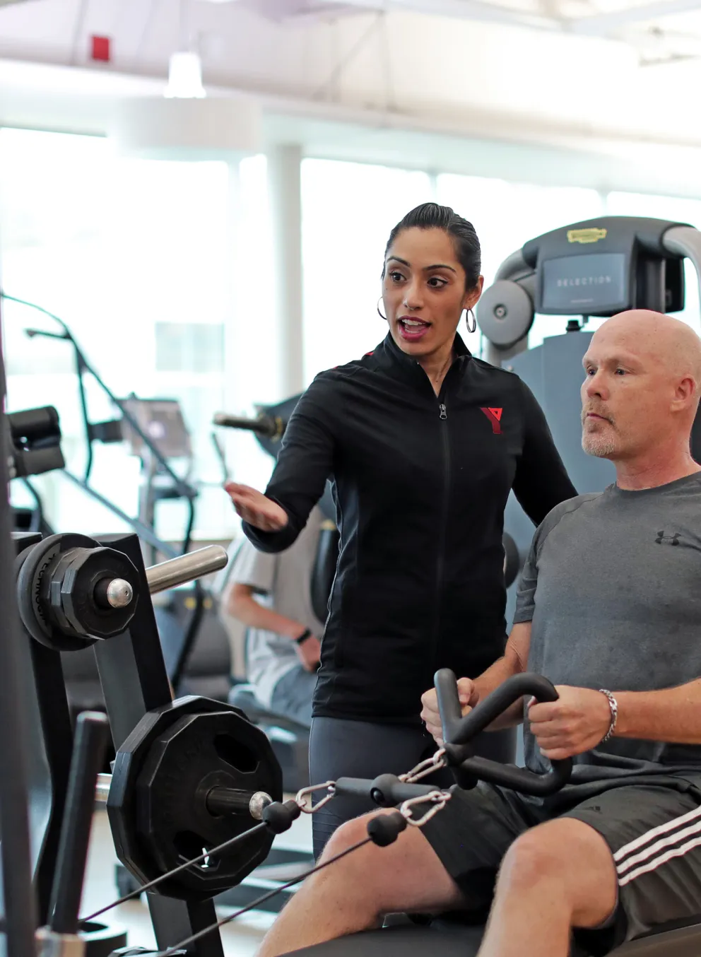 health coach guiding member through low rows exercise