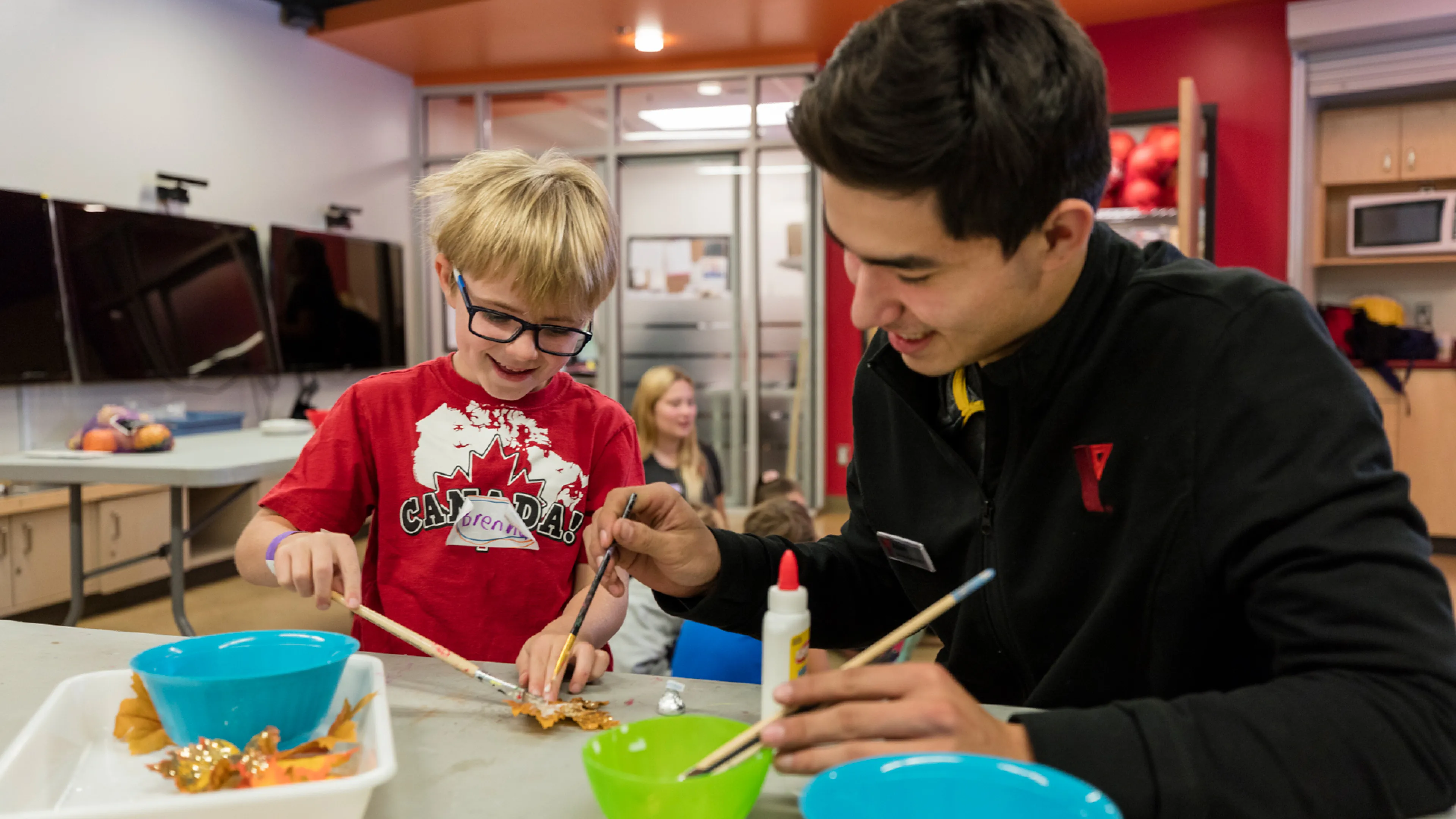 Staff member and child painting