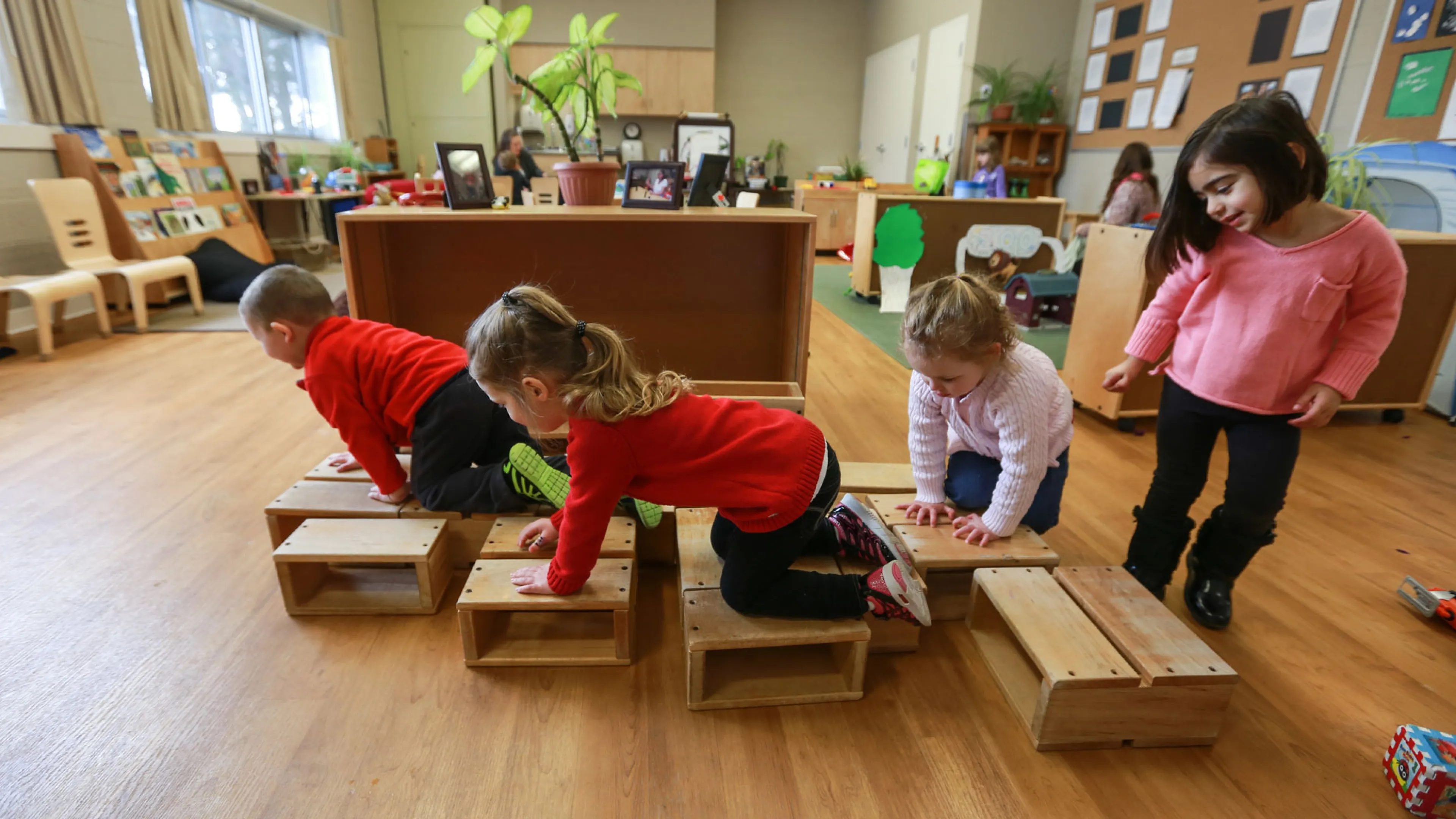 group of children playing on natural wooden blocks
