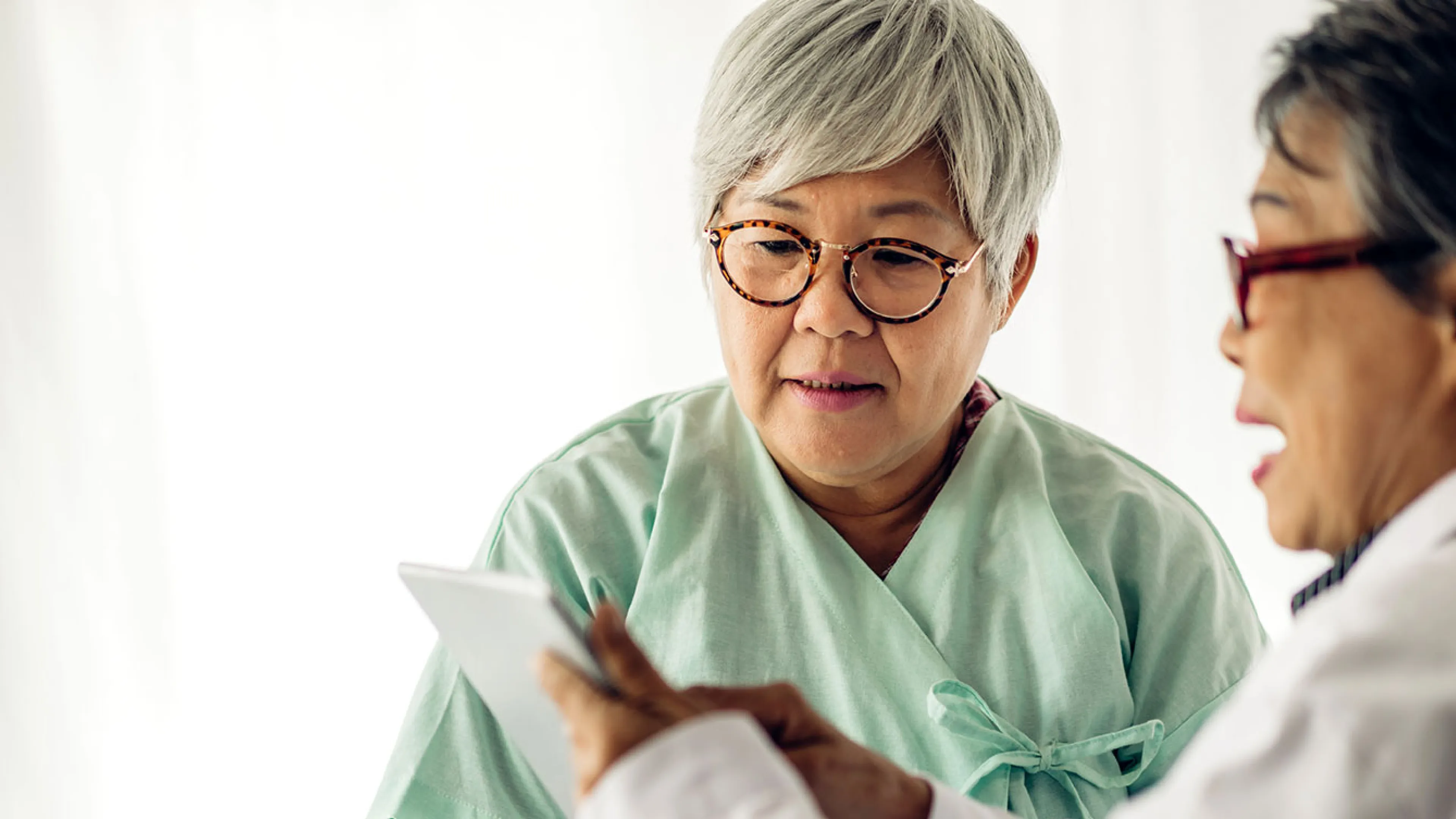 Doctor showing information to senior patient