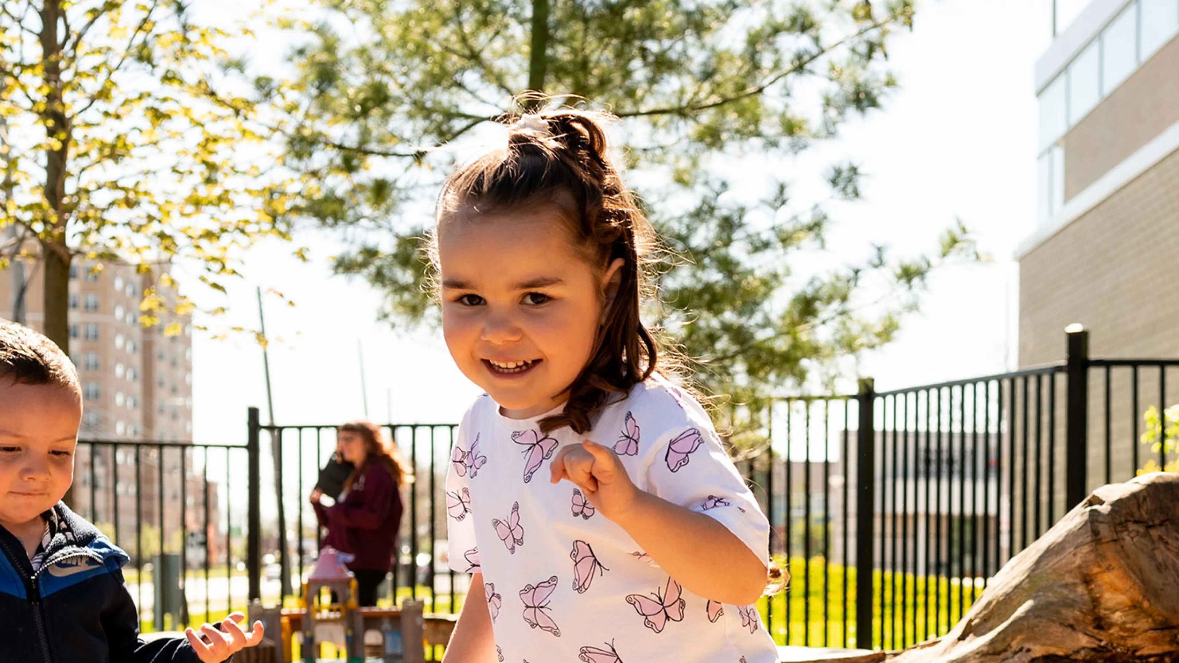 girl and boy playing in natural outdoor playground