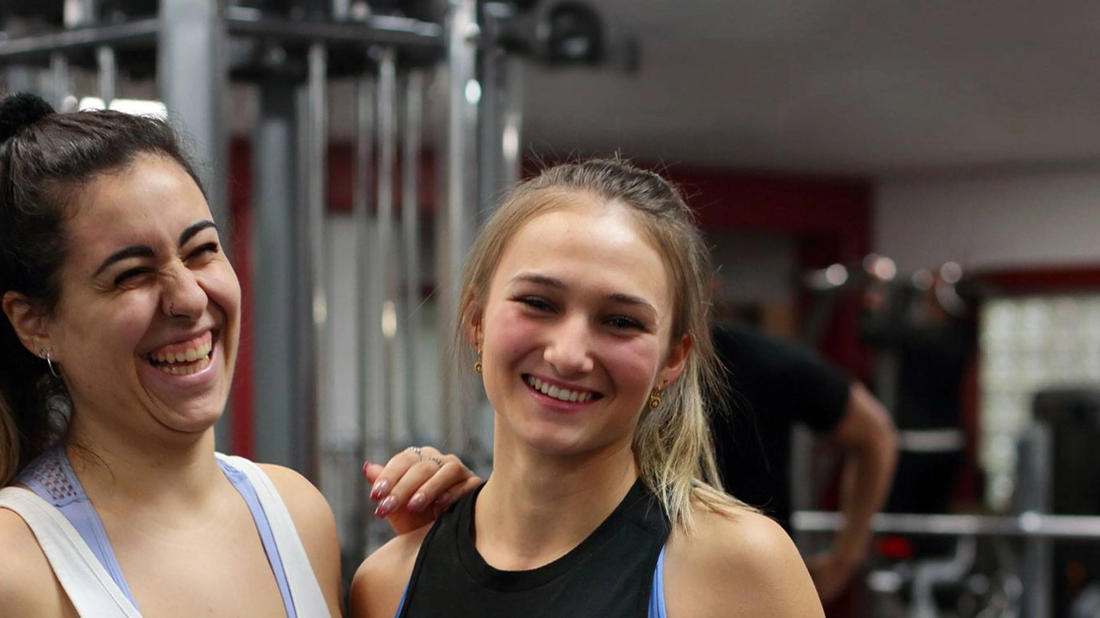 two women laughing together in a YMCA fitness centre