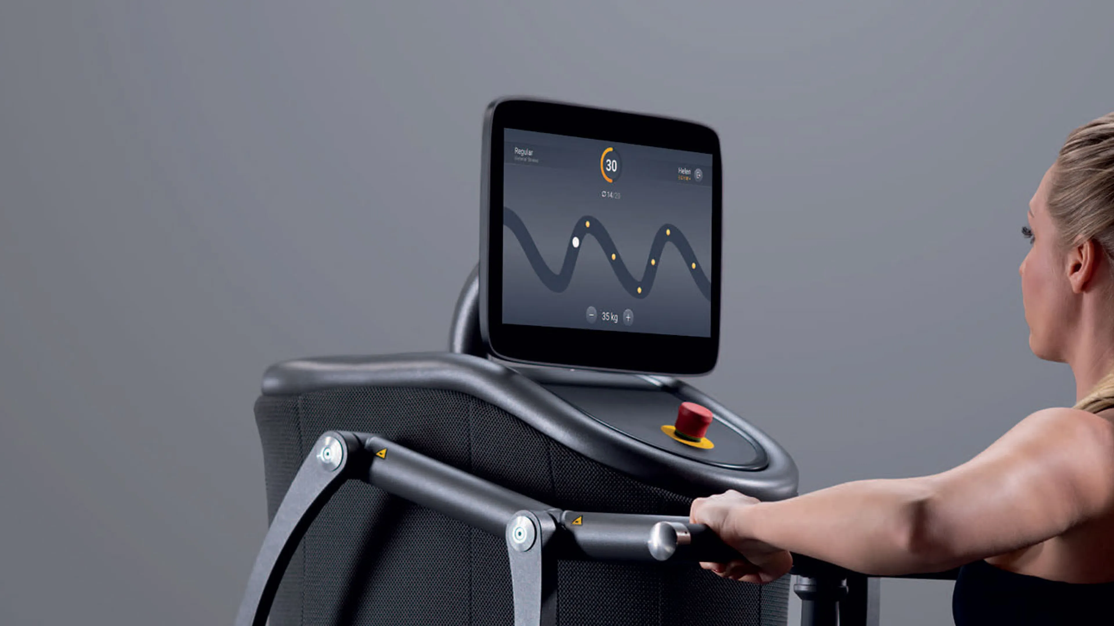a young woman engages in an interactive workout on an EGYM machine