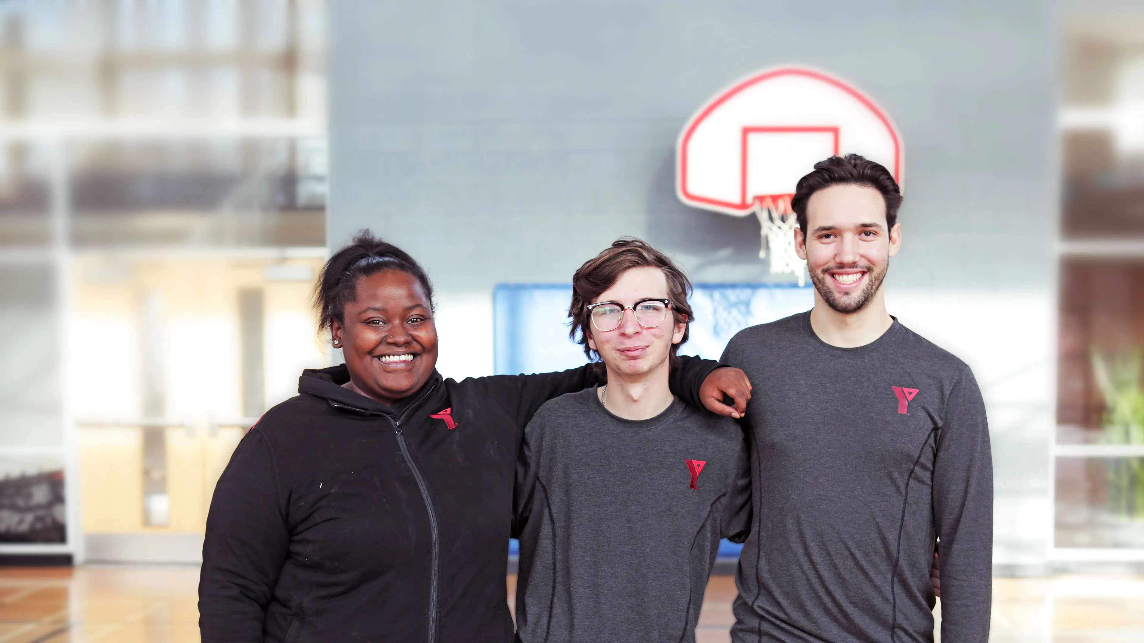 3 happy YMCA staff members in gymnasium