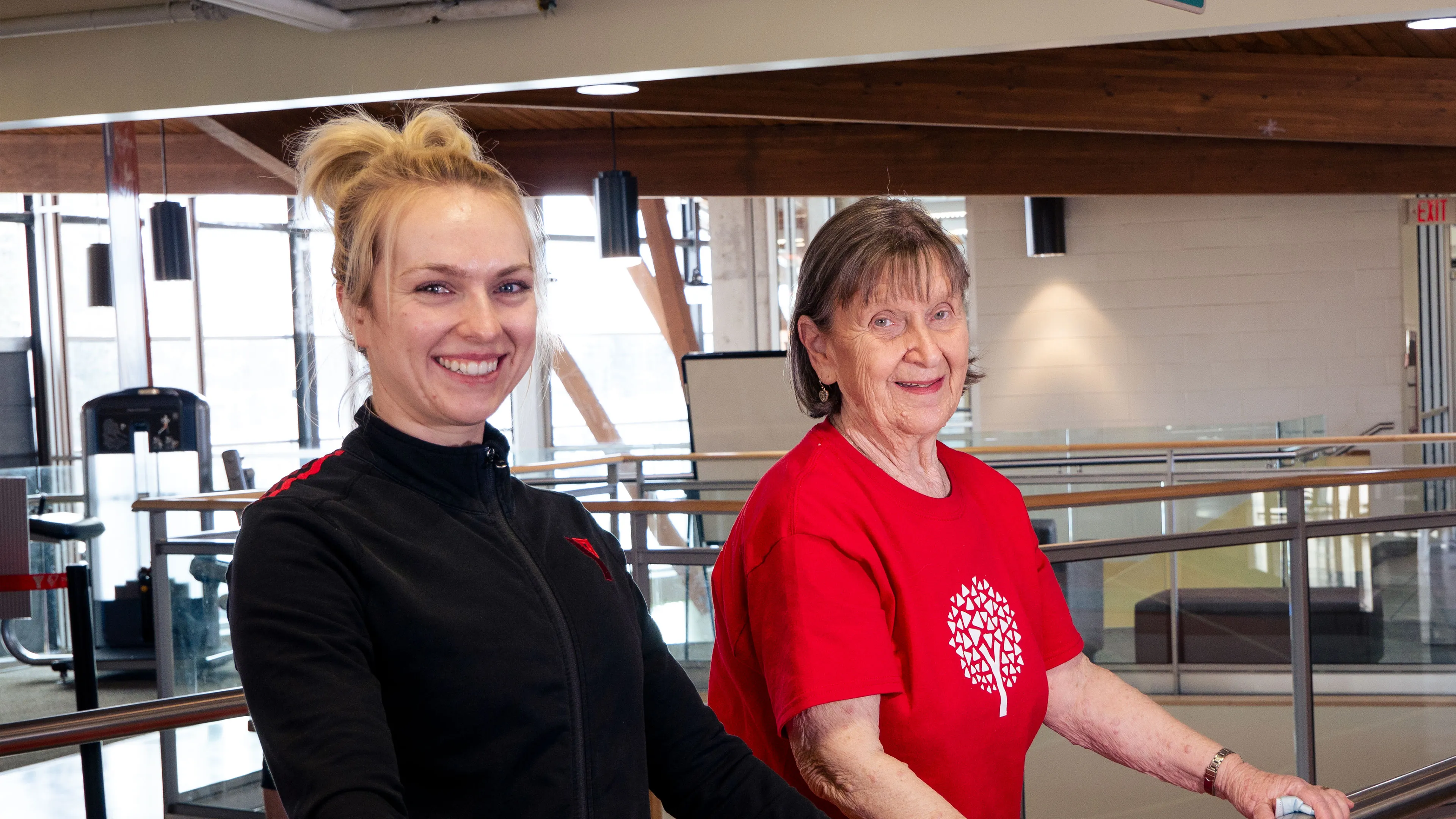 Healthy Aging participant and coach stretch using railing