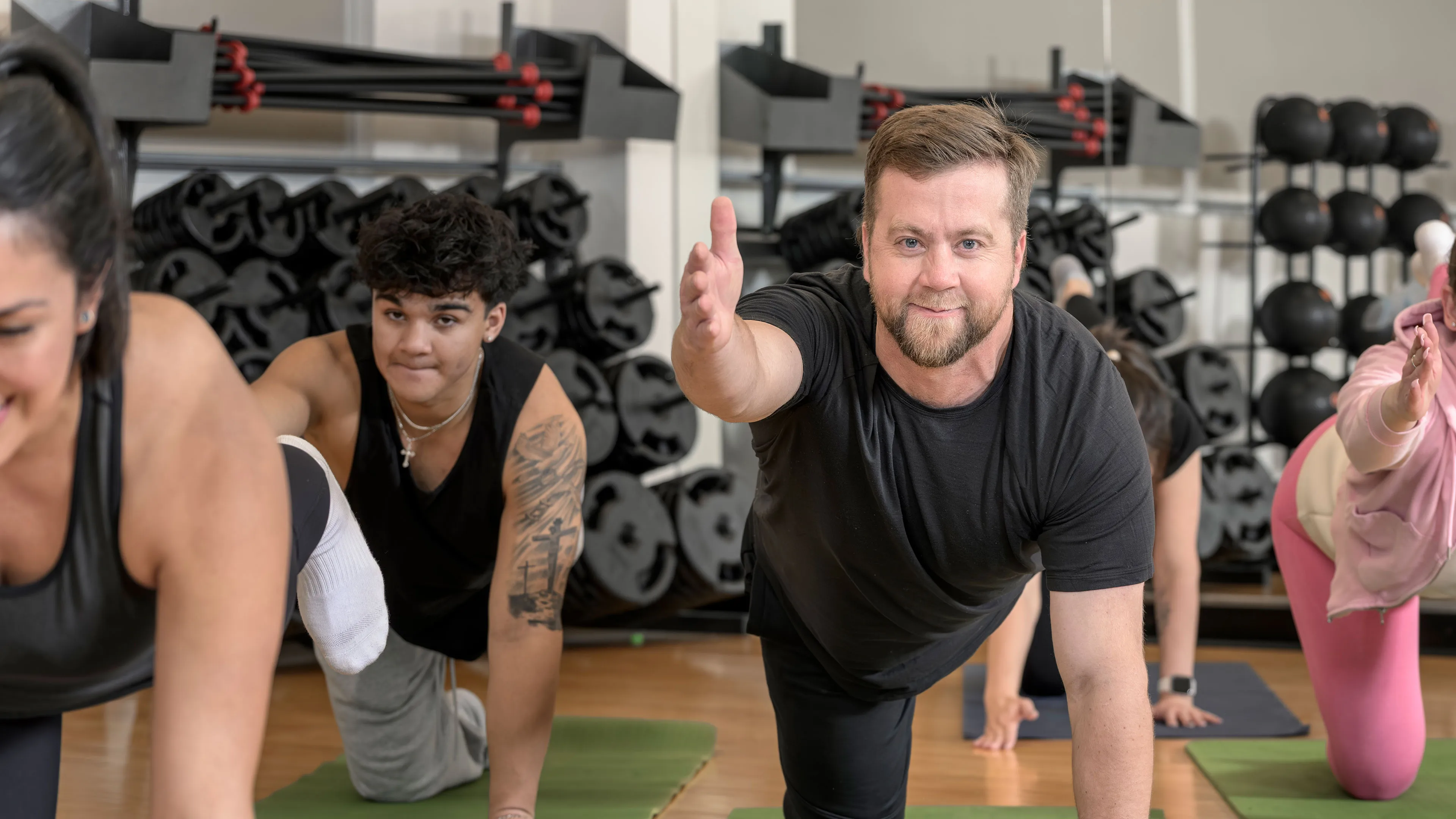 middle aged man participating in yoga class doing balancing table posemiddle aged man participating in yoga class doing balancing table pose