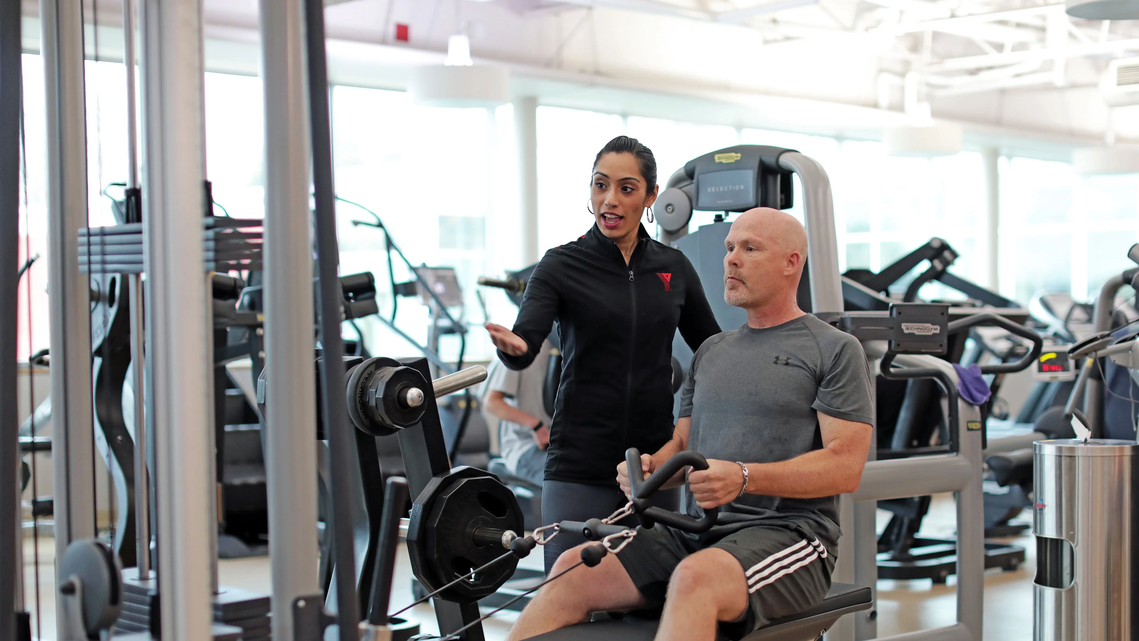 health coach guiding member through low rows exercise