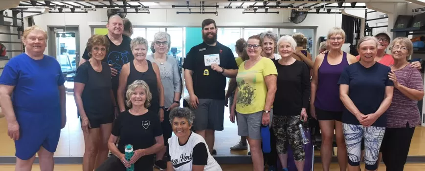 Etienne surrounded by smiling members who presented him with a card