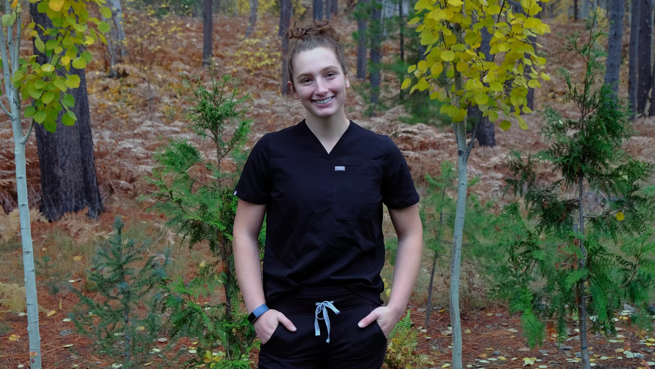 woman in black jumpsuit in the woods