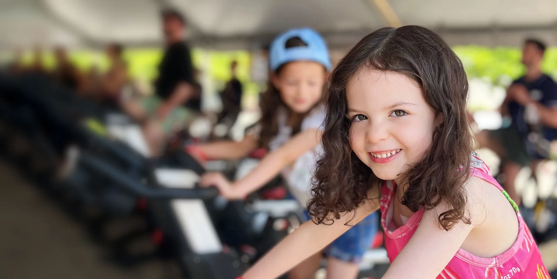 smiling girl riding stationary bike at the event