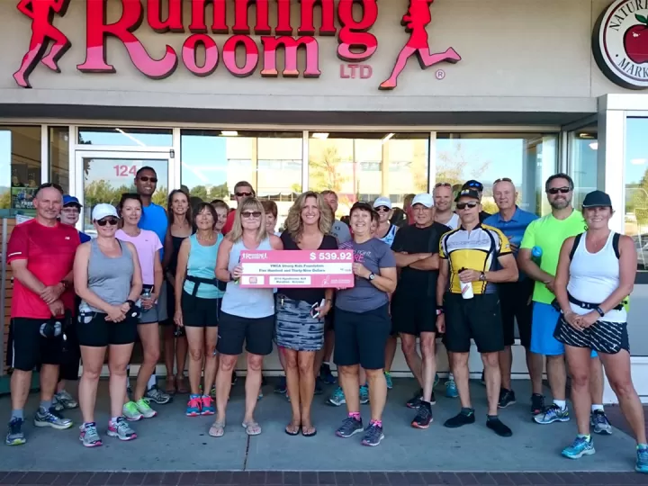 Kelowna Running Room staff holding a large check