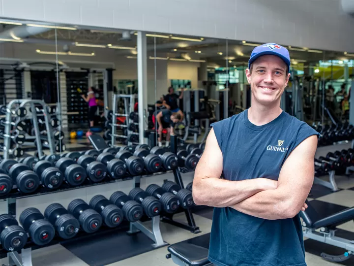 Austin smiling in front of the free weights
