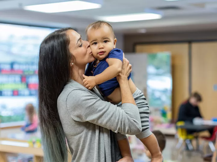 Brandi holding and kissing a baby