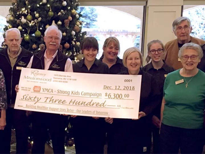 Missionwood Retirement Resort staff and seniors holdign a large check