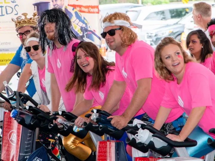 people in pink shirts riding bikes