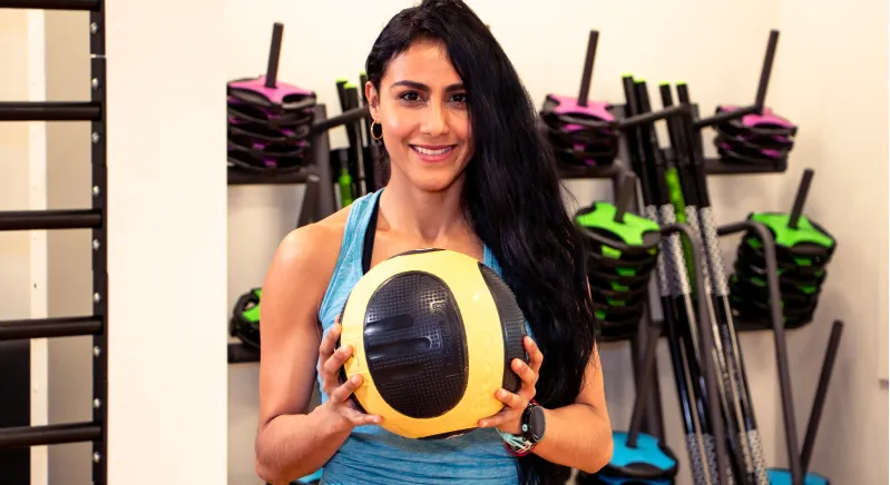 Mariely smiling holding a medicine ball 
