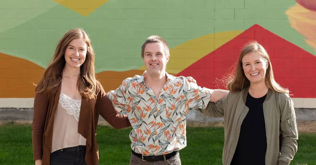outdoor photo of smiling community members by Rutland mural