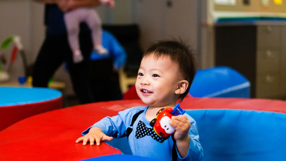 Child holding red toy truck