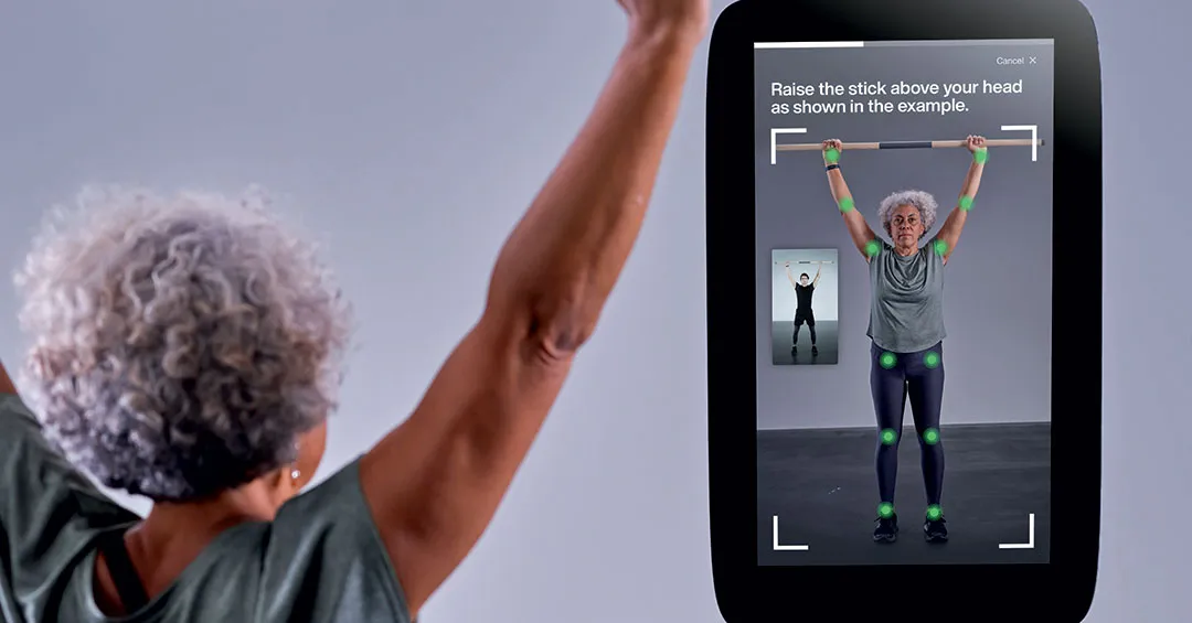 senior woman raises a stick above her head as part of the set up process