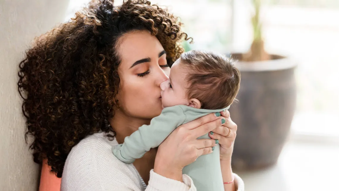 mother giving her baby a kiss