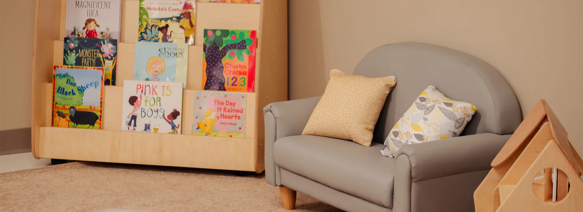 reading corner with books, dollhouse and child-sized couch