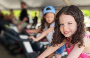 smiling girl riding stationary bike at the event