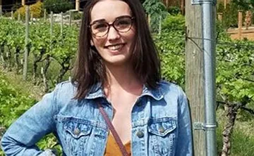 Kristen smiling in the vineyard