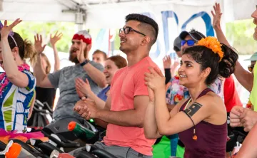 people raising their hands on bikes