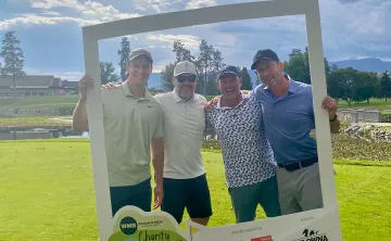 Wilson M Beck team standing behind giant photo frame on the golf course